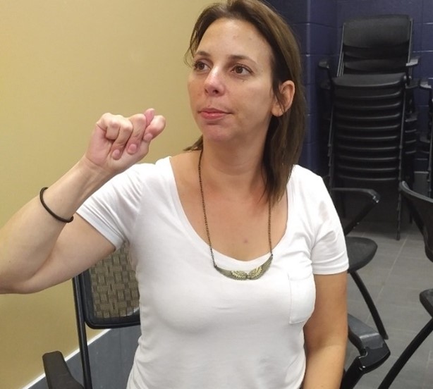 A staff member at the Quinte Sports and Wellness Centre learning beginner American Sign Language to serve Deaf customers. 