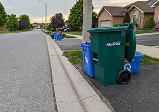 Photo of Compost and Recycling bins at the curb of a street.