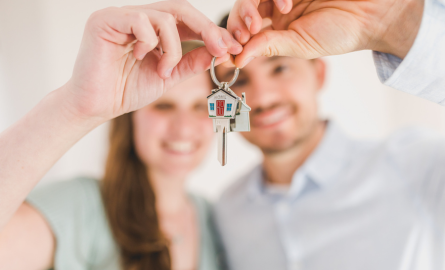 Couple hugging and holding house key