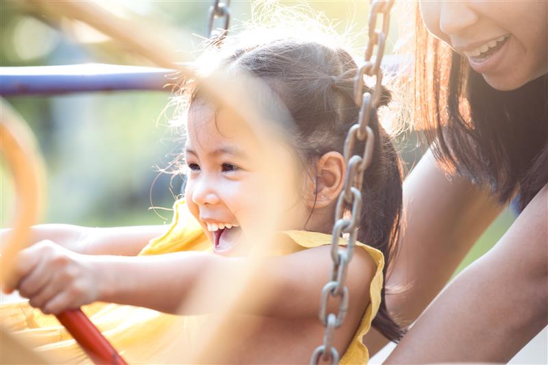 Child laughing on swingset
