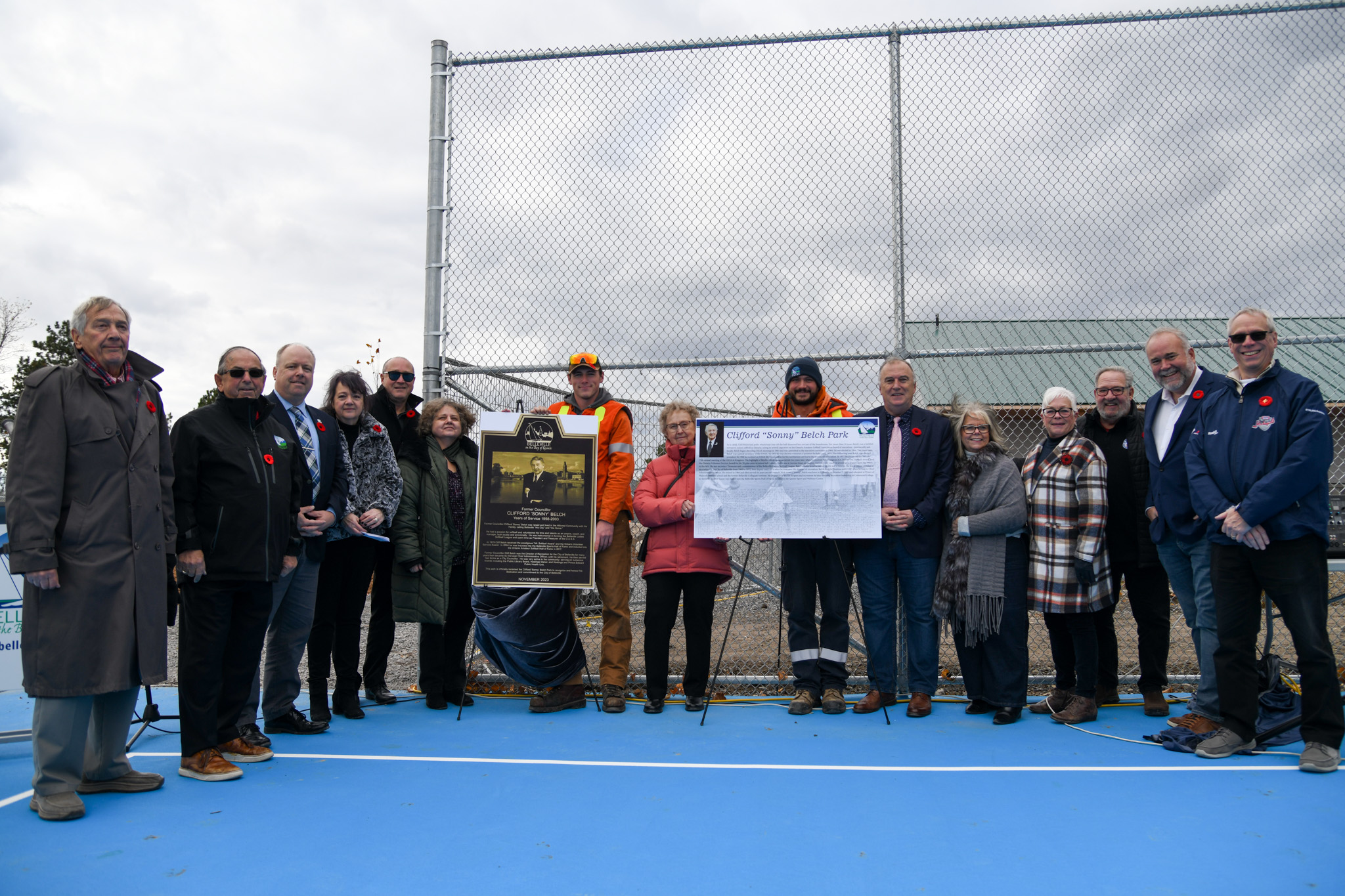 Mayor and invited guest and family stand with Clifford Belch plaque