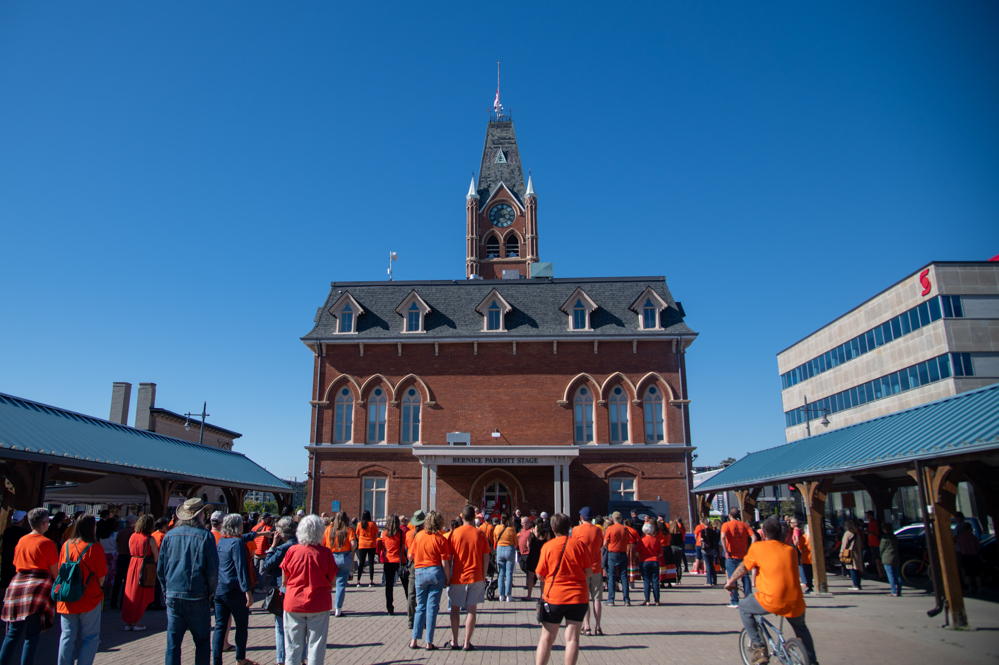 Group of individuals wearing orange shirts stand in Market Square