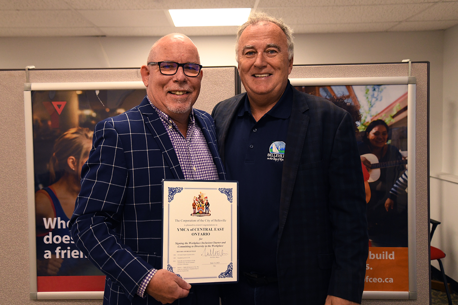 Photo of Mayor Ellis with David Allen from the YMCA holding the workplace inclusion charter.