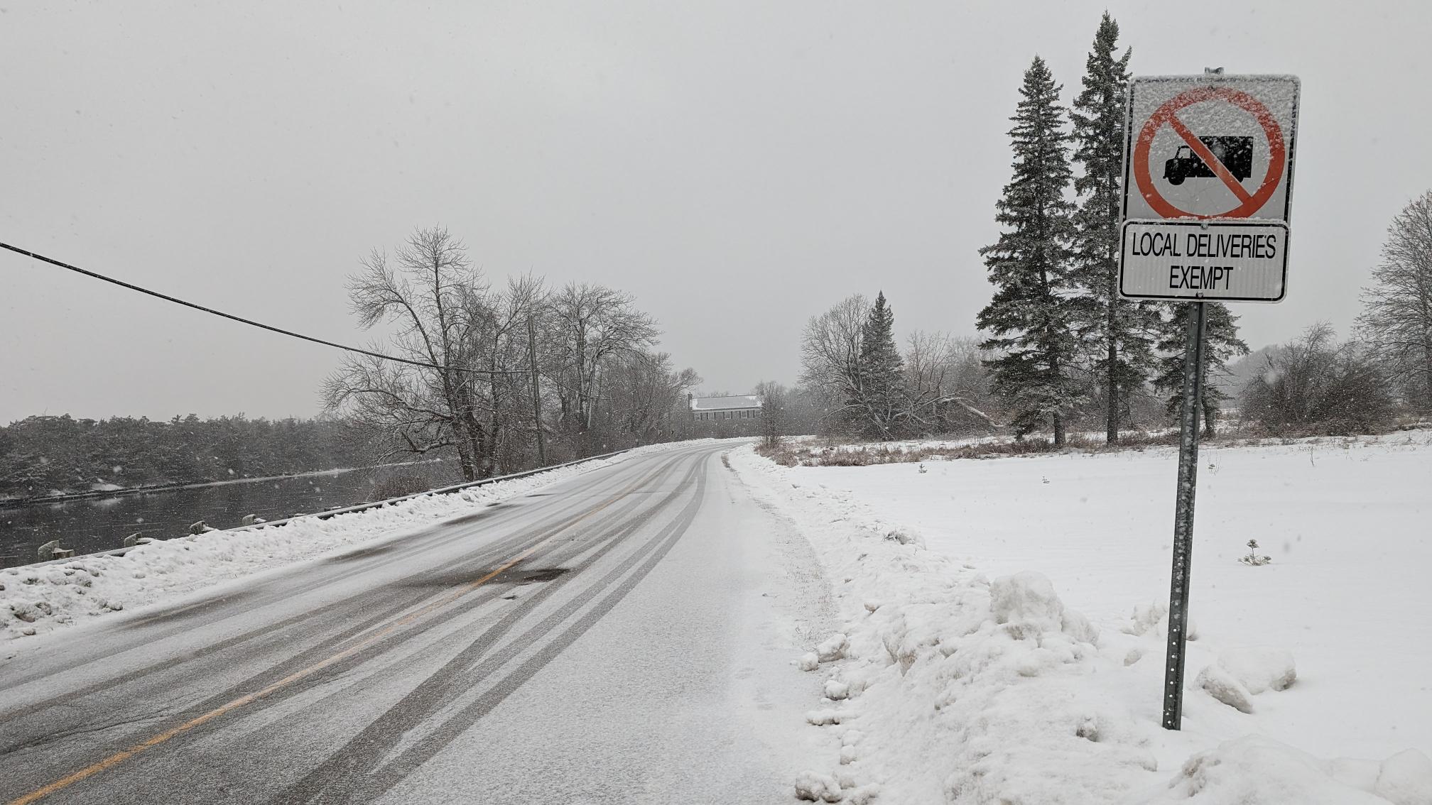 Half-load restrictions street sign along snowy road in Belleville