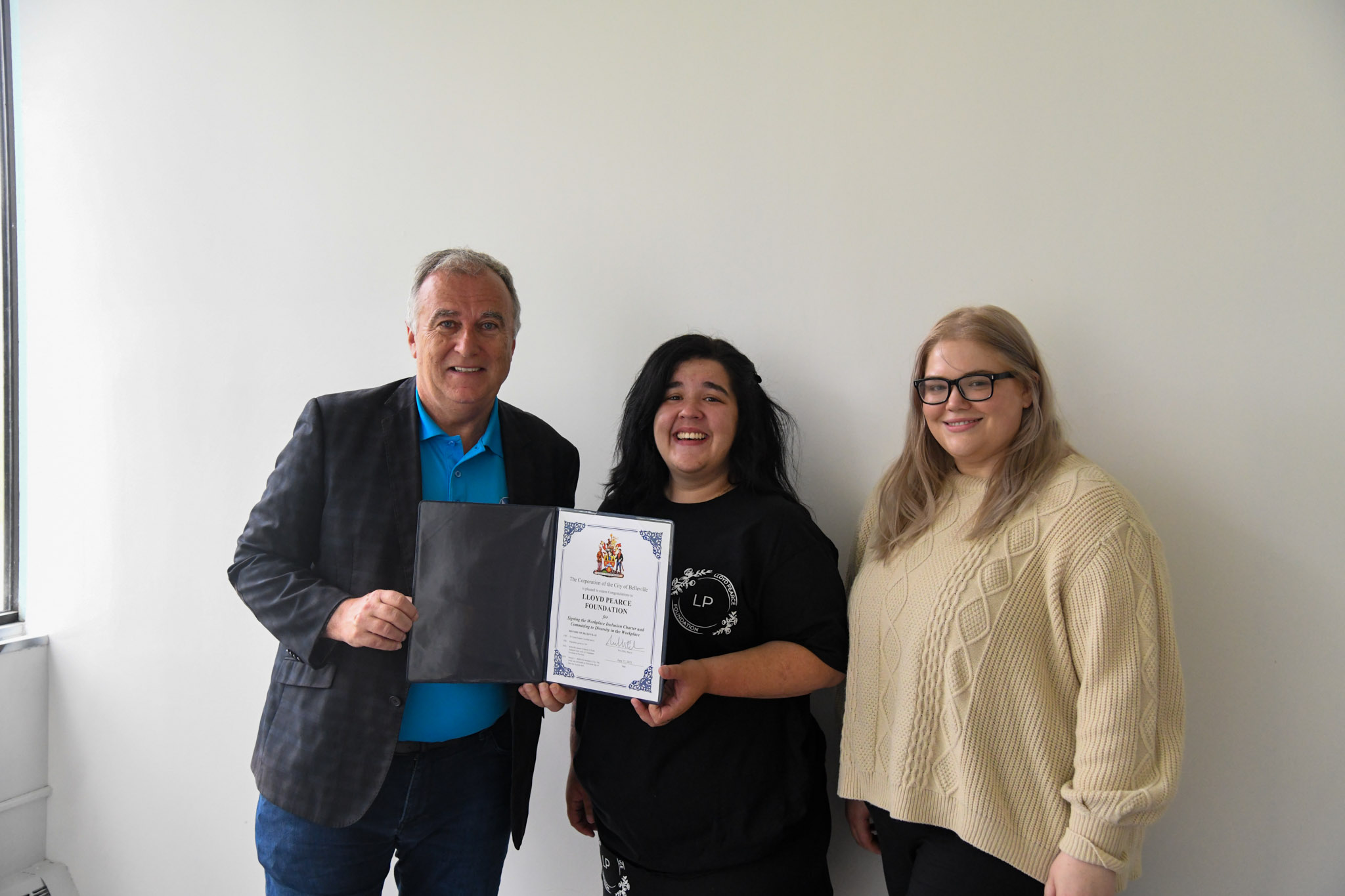 Photo of Mayor Ellis and the Lloyd Pearce Foundation holding the workplace inclusion charter.