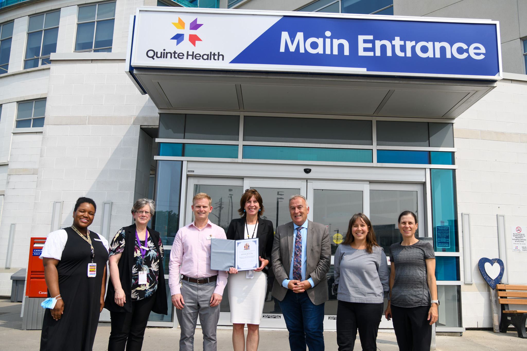 Photo of Mayor Ellis and representatives from Quinte Health Holding the Inclusion Charter in front of the Belleville General Hospital.