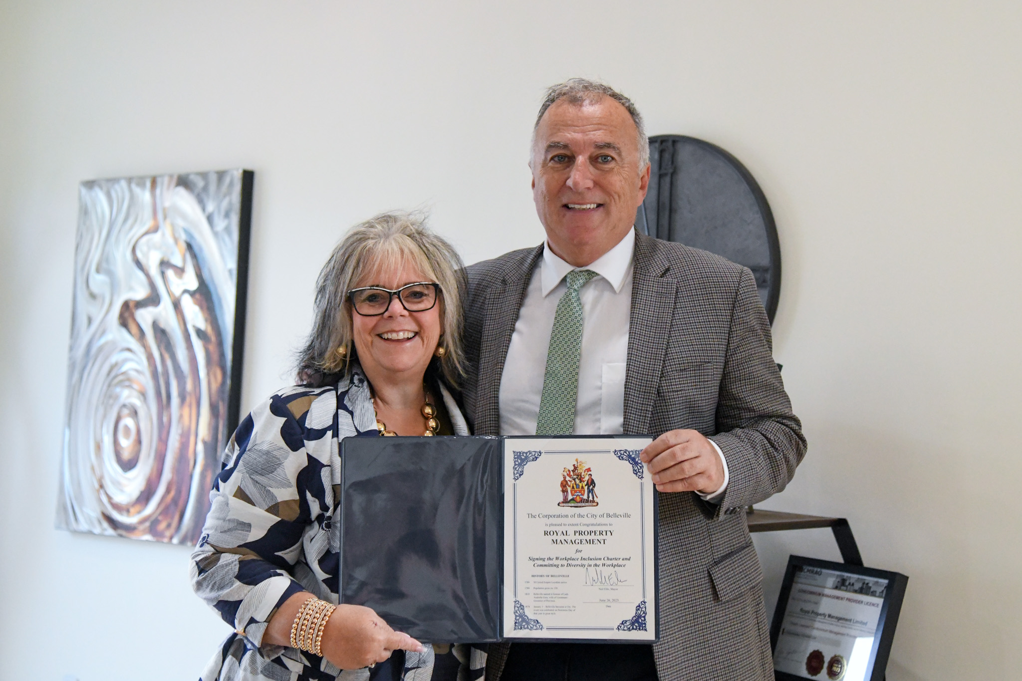 Photo of Mayor Ellis and owner of Royal Property Management, Barbara Enright-Miller holding the Inclusion Charter