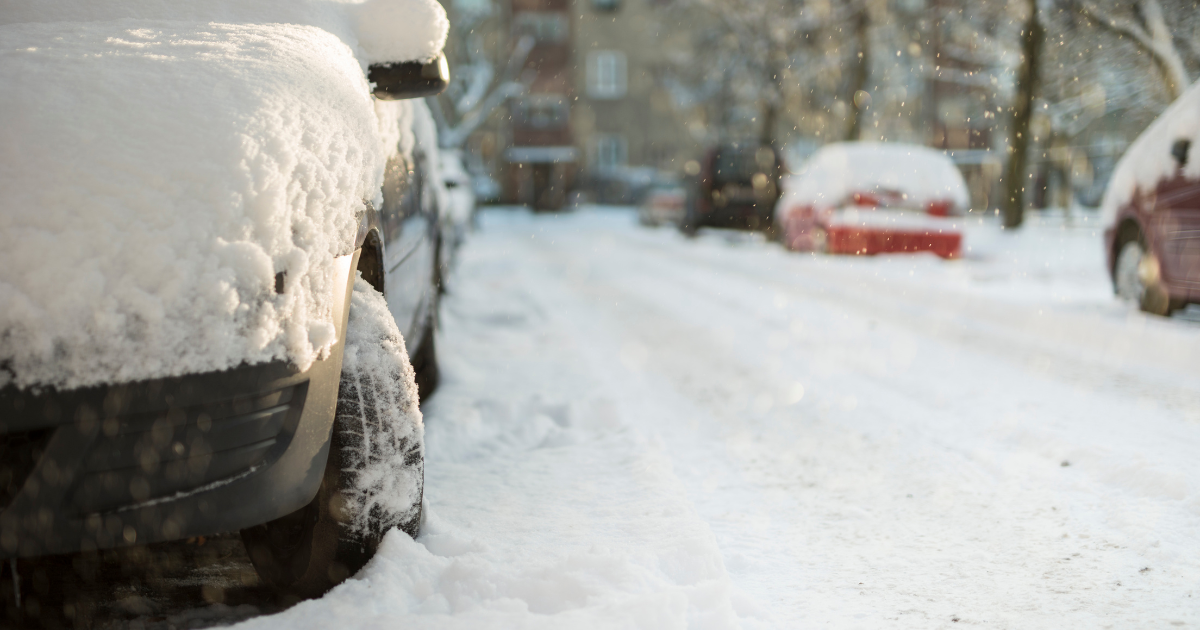 cars parked on road with snow