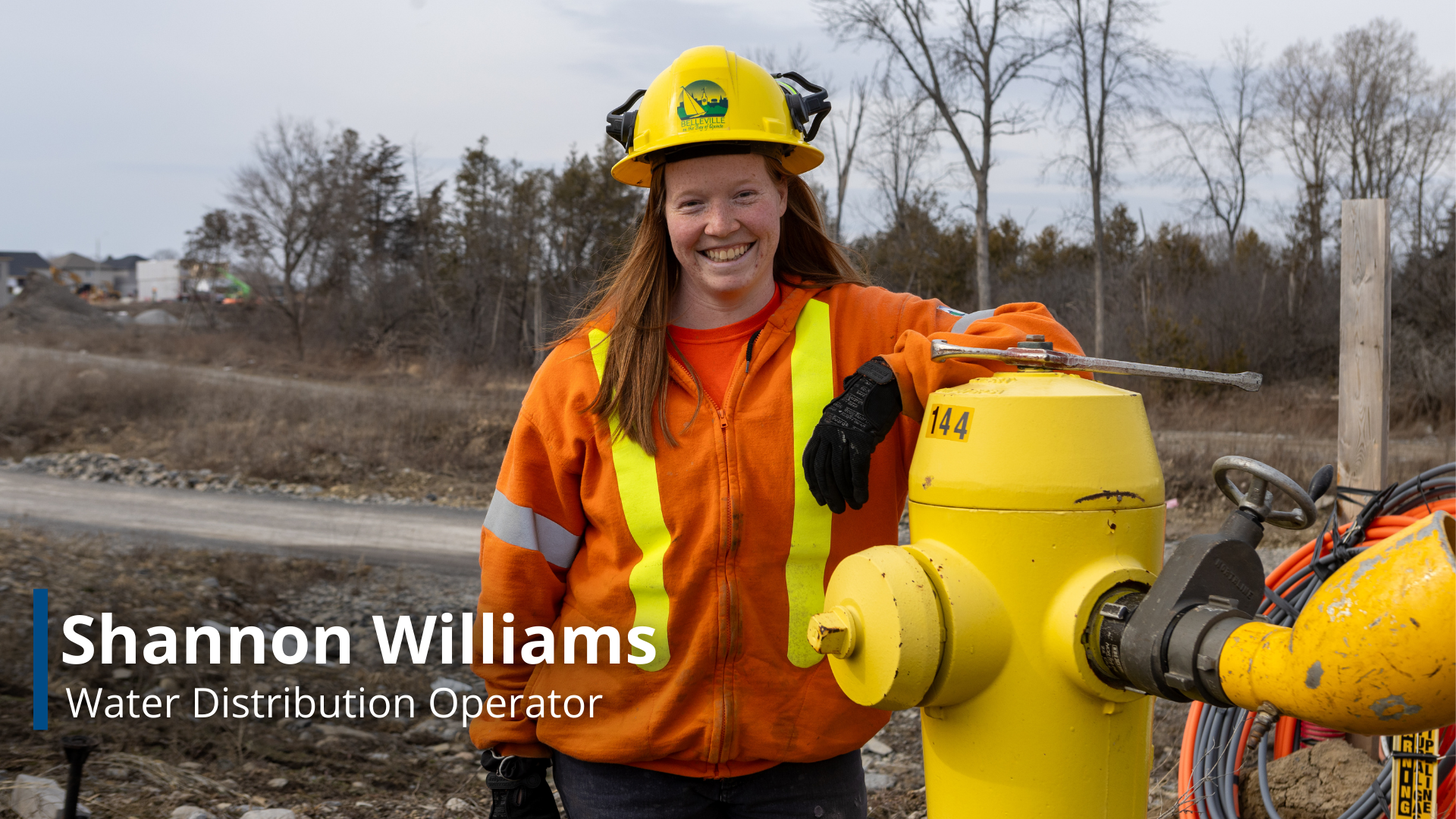 A photo of Shannon Williams, a Water Distribution Operator, leaning against a fire hydrant.
