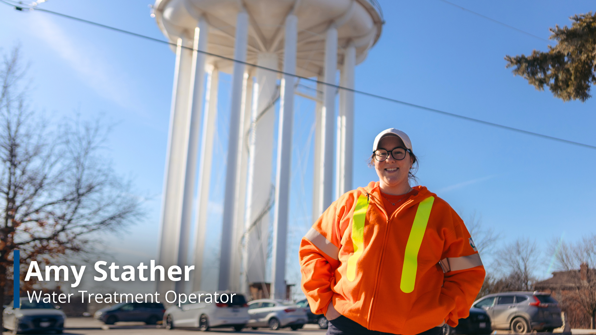 A photo of Amy Slather, a Water Treatment Operator, with the Belleville Water Tower in the background.