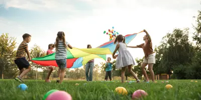 Children playing parachute game in park