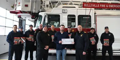 BFES members and Enbridge rep in front of BFES truck holding donations