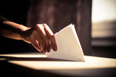 Person putting ballot in box