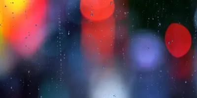 Emergency lights blurred through wet glass