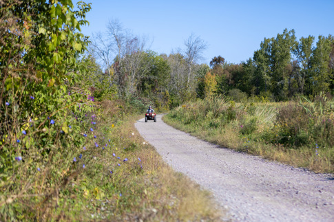 Photo of a gravel trail with an ATV in the distance.