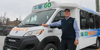 Photo of a transit worker in front of the mobility bus.