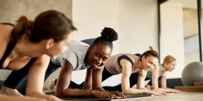 Women planking and smiling at eachother